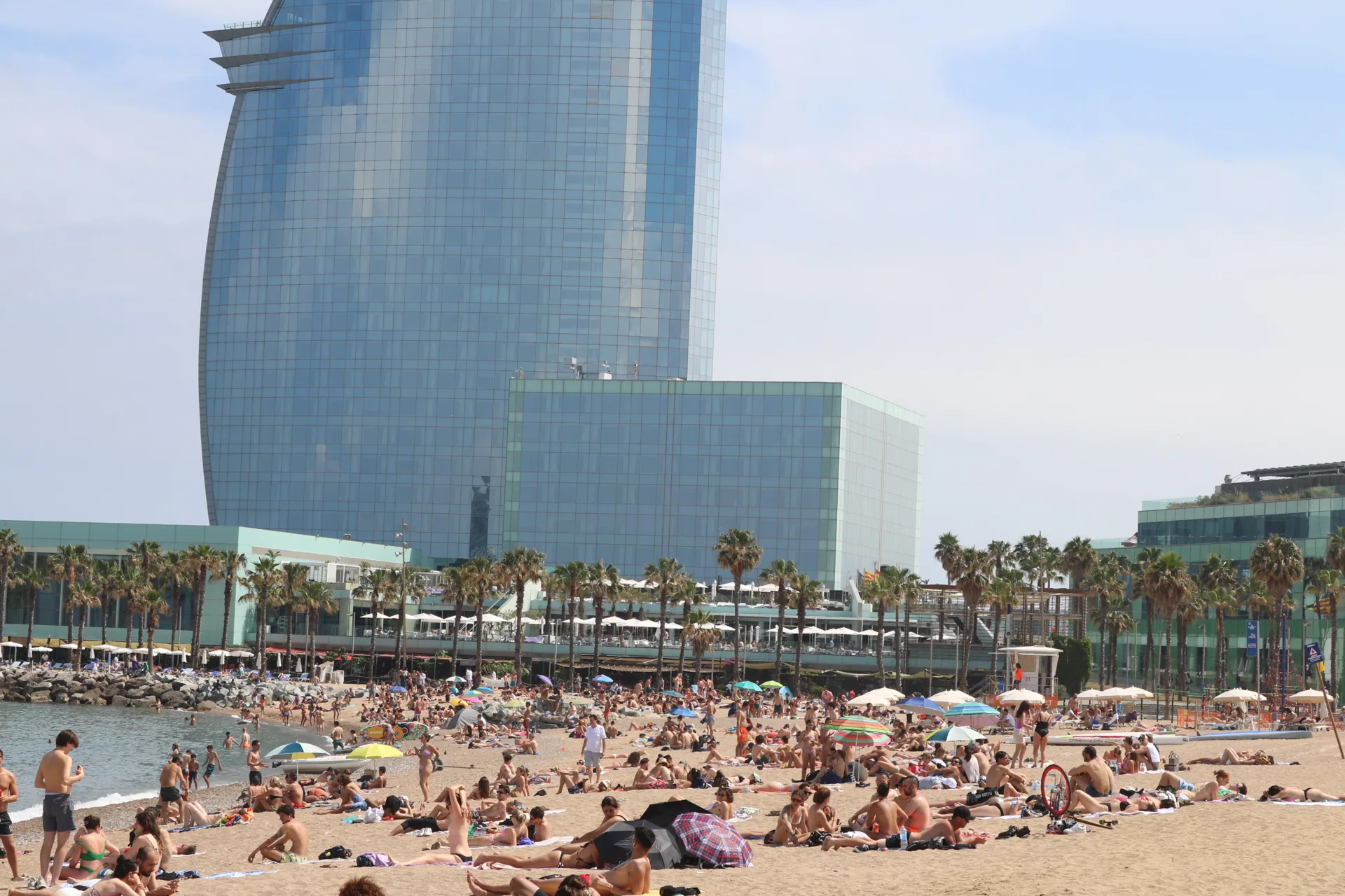 People enjoying the beach beside the sea in Barcelona